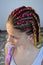 A girl with a fashionable set of multicolored braids Kanekalon. Colored artificial strands of hair.