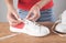 Girl fastening shoelaces on sport sneakers