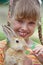 Girl feed rabbit with carrot.