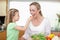 Girl feeding her mother with tomato