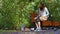 Girl feeding pigeons in the city Park.Sitting on the bench and throwing the birds food.A flock of pigeons on the street near peopl