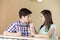 Girl Feeding Strawberry Ice Cream To Brother In Parlor