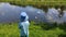 A girl feeds gulls and ducks on the bank of a small river