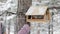 Girl feeds a squirrel with nuts at winter park.