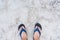 .Girl feet in blue slippers on sand beach texture. Tropical seashore. Seaside.Thailand