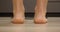 Girl feet standing on weighing scale. Woman on scales. Female checking weight or overweight, close up, backside view