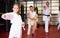 Girl fighting karate stand in the gym. Children in pair practice karate