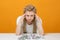 Girl with financial problems sits at table, hands holding his head, crumpled bank notes lie on the table