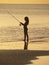 Girl fishing on sunset beach