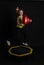 Girl on a fitness trampoline on a black background in a yellow t-shirt activity female healthy leap, workout rebounder