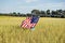 girl with flag in wheat field