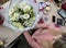 A girl, a florist-designer holds out a beautiful, festive bouquet of red flowers