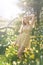 A girl in a flower dress in a meadow with  flowers.