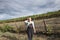 A girl with flower standing in the vineyard