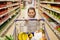 Girl with food in shopping cart at grocery store