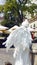 Girl in form of an angel in city. White live angel statue