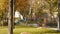 A girl with foxy hair runs through the park with purchases in multi-colored paper bags