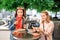 Girl friends students eating Currywurst fast food German dish pork sausage in outdoor street food cafe