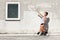 Girl in front of and old wall pointing a window with one arm