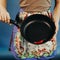 The girl with a frying pan. Are red sharp Chile pepper on a frying pan