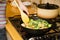 Girl frying vegetables on pan