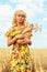 Girl with a full pack of bread in a field with ripe wheat. Model posing on the background of crops ready for harvest