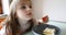 Girl and funny faces and strawberries cake in the kitchen