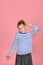 A girl with a funny hairstyle in a striped T-shirt touches her hair, is surprised and makes funny faces