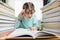 A girl in funny round glasses with large lenses looks at a book in surprise.