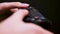 Girl gamer playing video game with wireless joystick at home on black background. Concept. Close up of gamepad in female