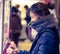 girl gamer in winter fashion is playing with crane doll machine in Game center for luck