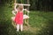 Girl in the garden playing with swings.