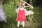 Girl in the garden playing with swings. baby playing in the garden