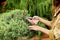 Girl gardener in working clothes and straw hat cuts garden scissors evergreen