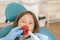 girl getting dental filling treatment at molar tooth with ultraviolet technology. Image of little girl having her teeth checked by