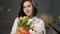 Girl with gifts, attractive young woman alone in room holds bouquet of flowers yellow tulips in her hands gift soft toy