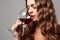 Girl with glass of red wine.Beautiful blond woman drinking red wine