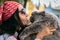 Girl with glasses and a headscarf face to face with a British long-haired cat on a blurred background. Love to the animals.