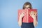 Girl with glasses peeping from behind a big book.