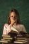 a girl with glasses poses with books