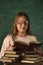 a girl with glasses poses with books