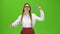Girl in glasses raises a card and shows a thumbs up smiling . Green Screen