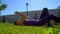 A girl in glasses reads a book sitting on a grass