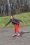 A girl with glasses rides roller skates. Seasonal outdoors children activity sport