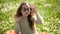 Girl with glasses sits in chamomile field on a sunny day. Sweet little girl outdoors. Happy girl portrait. Kids fashion