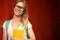 Girl in glasses smiles amid Burgundy wooden wall