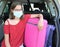 Girl with glasses and surgery mask before travel with suitcases