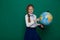 Girl with a globe in geography class at the board at school