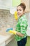 Girl Gloved washes cupboards, stove and sink in the kitchen