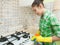 Girl Gloved washes cupboards, stove and sink in the kitchen